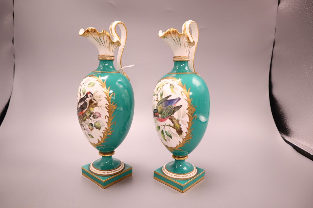 A pair of Coalport green glazed ewers, hand painted birds to the body, height 27cm